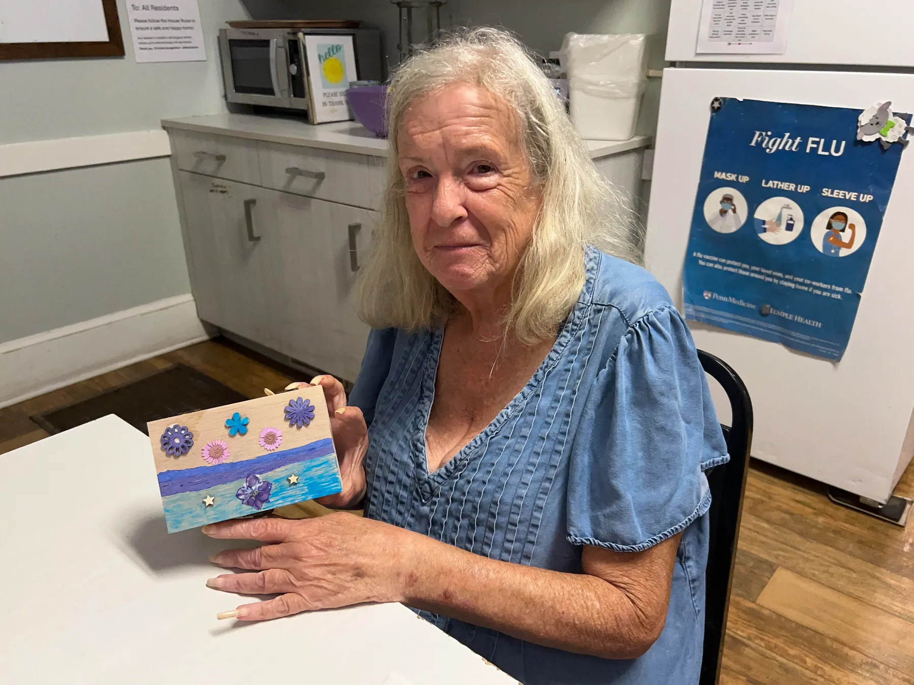 Resident showing a handmade craft project.