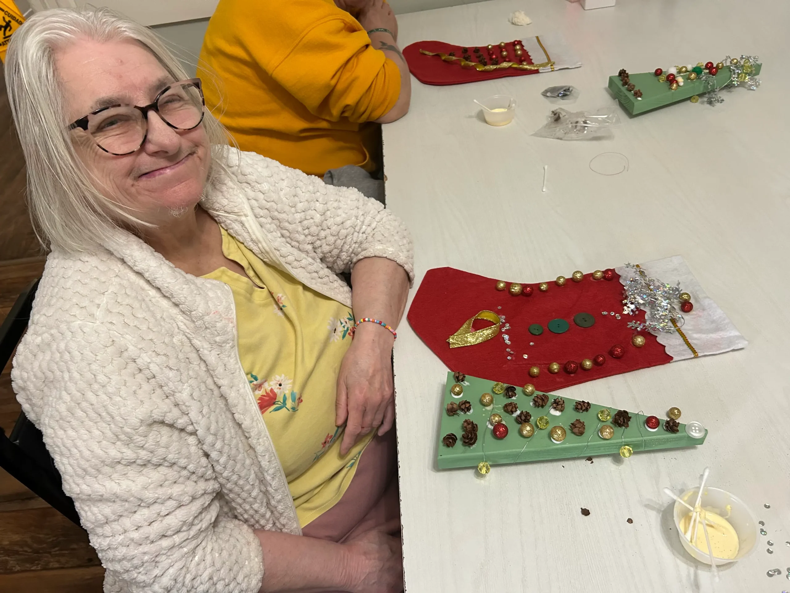 Resident crafting holiday decorations at a table.