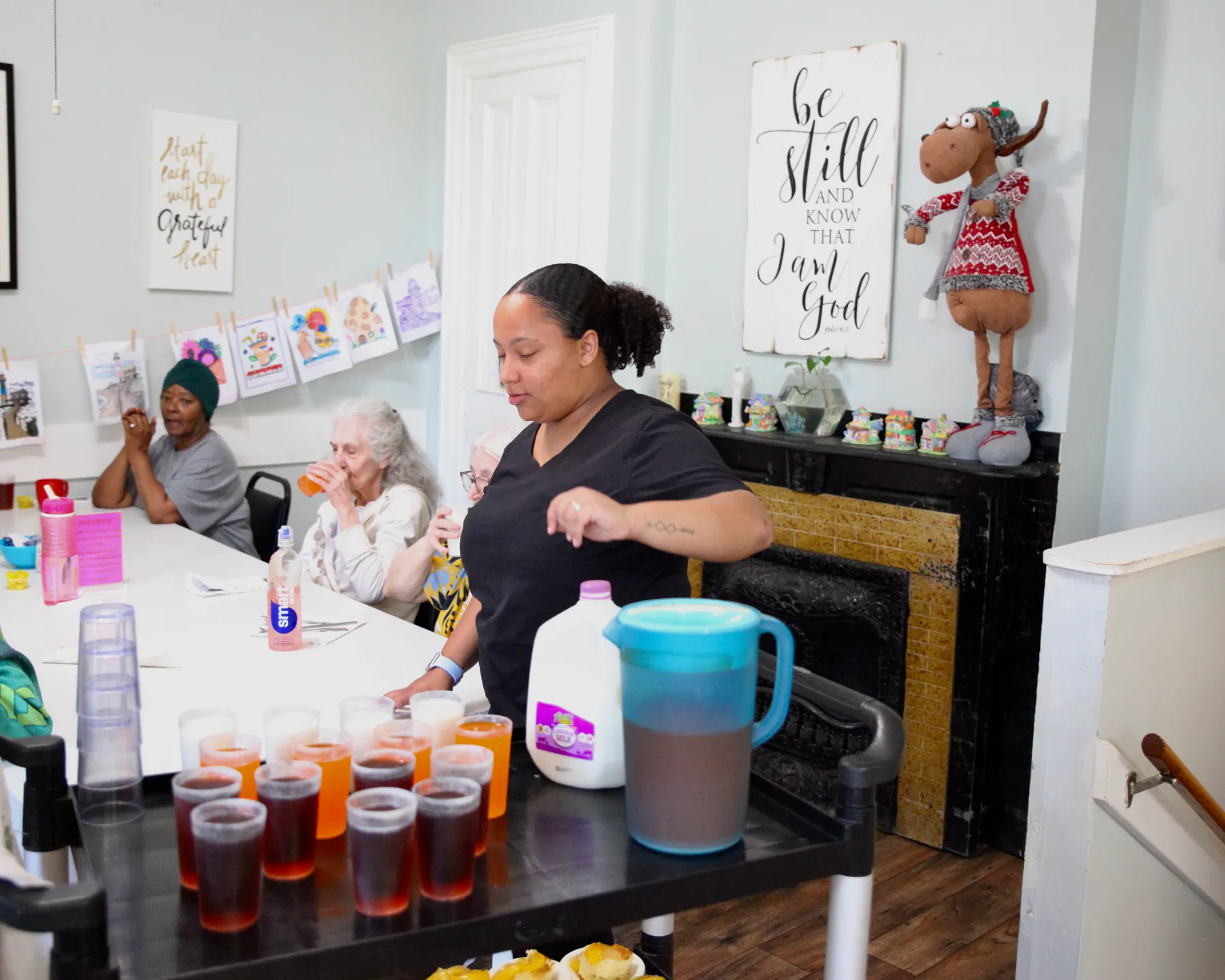 Care staff serving drinks to residents in a common area