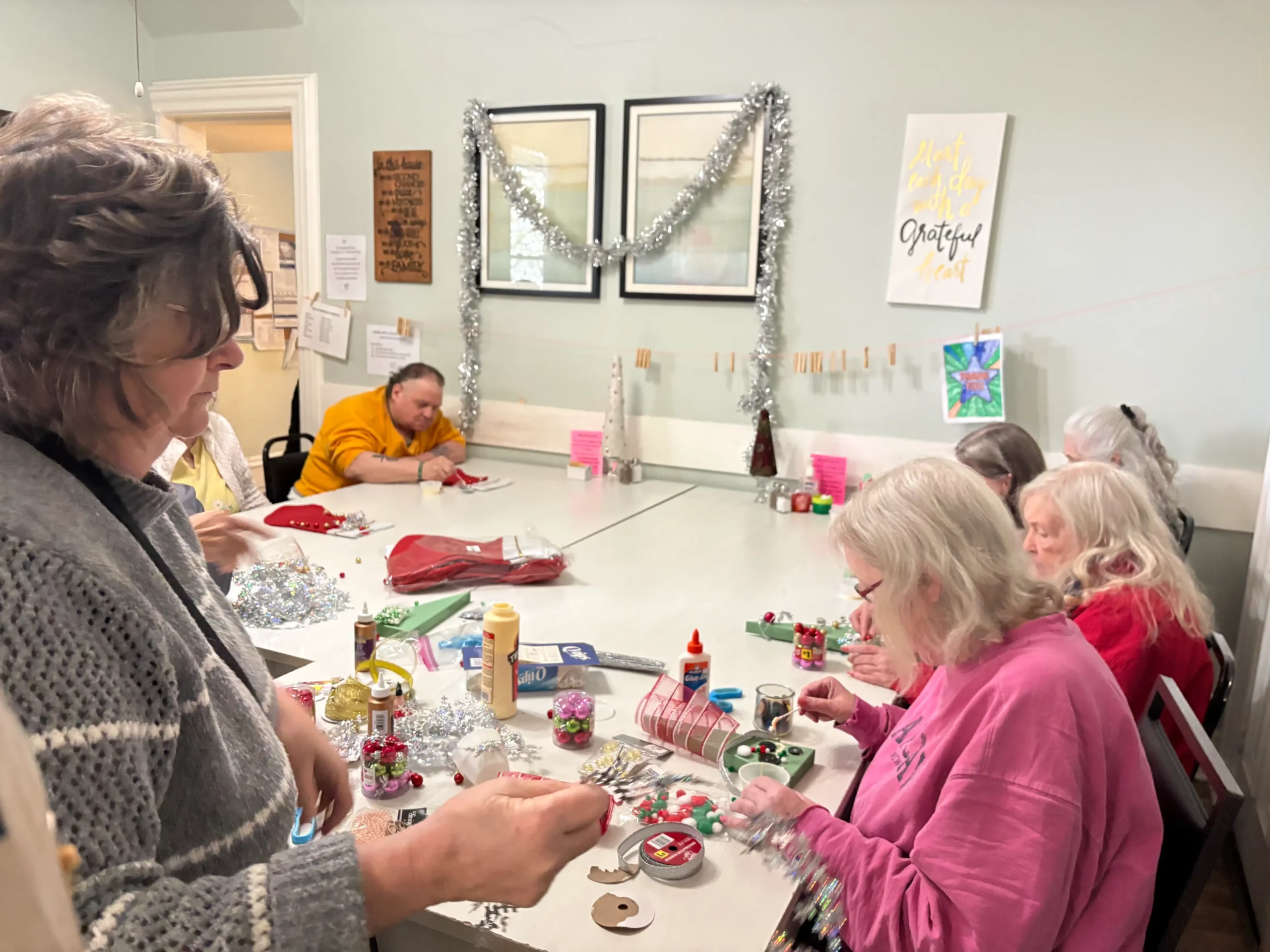 Residents engaged in craft activities around a table.