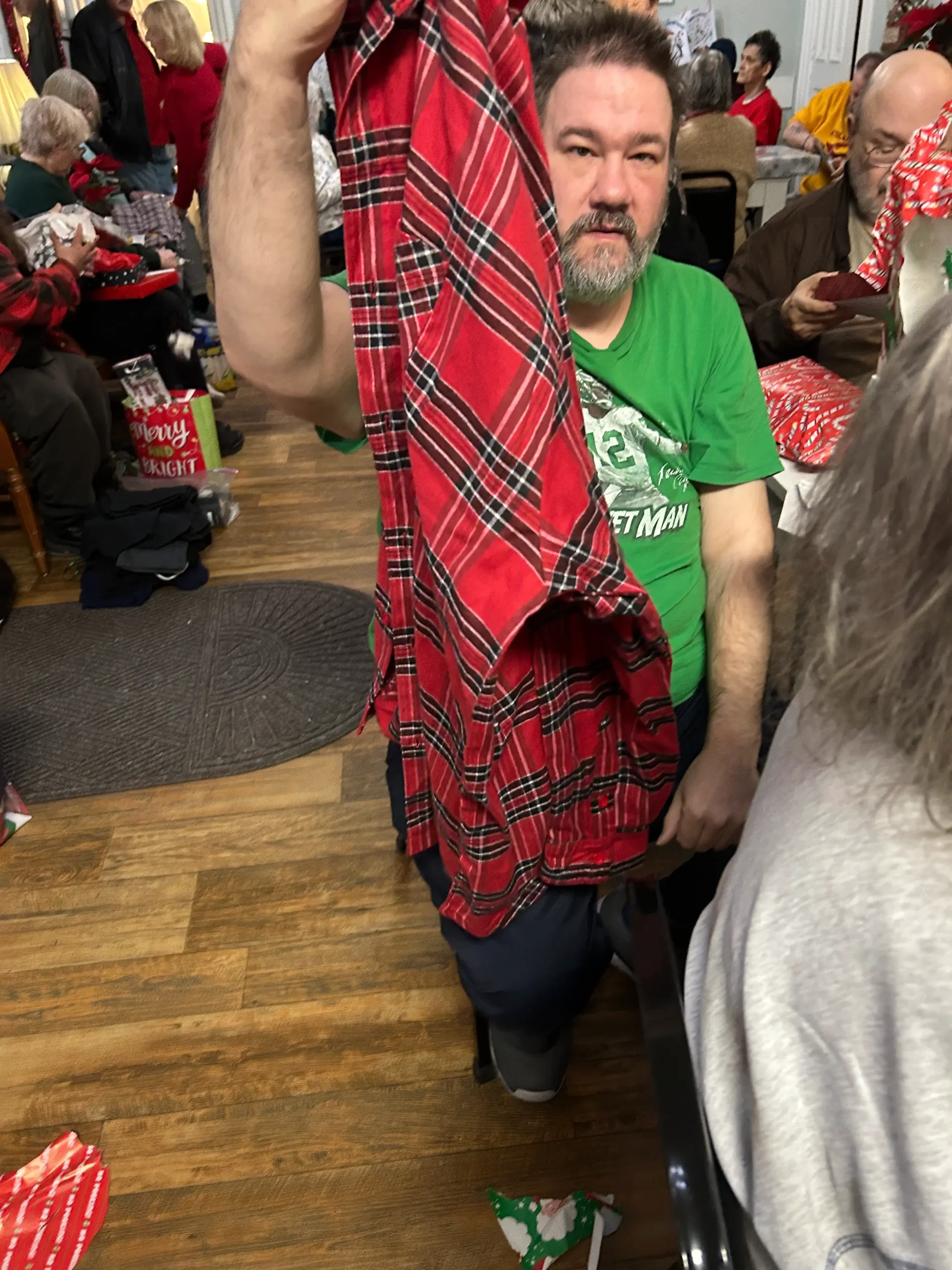 Resident enjoying a festive gathering while unwrapping gifts.