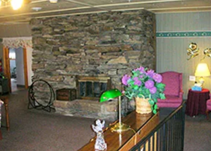 Cozy common area with stone fireplace and seating.