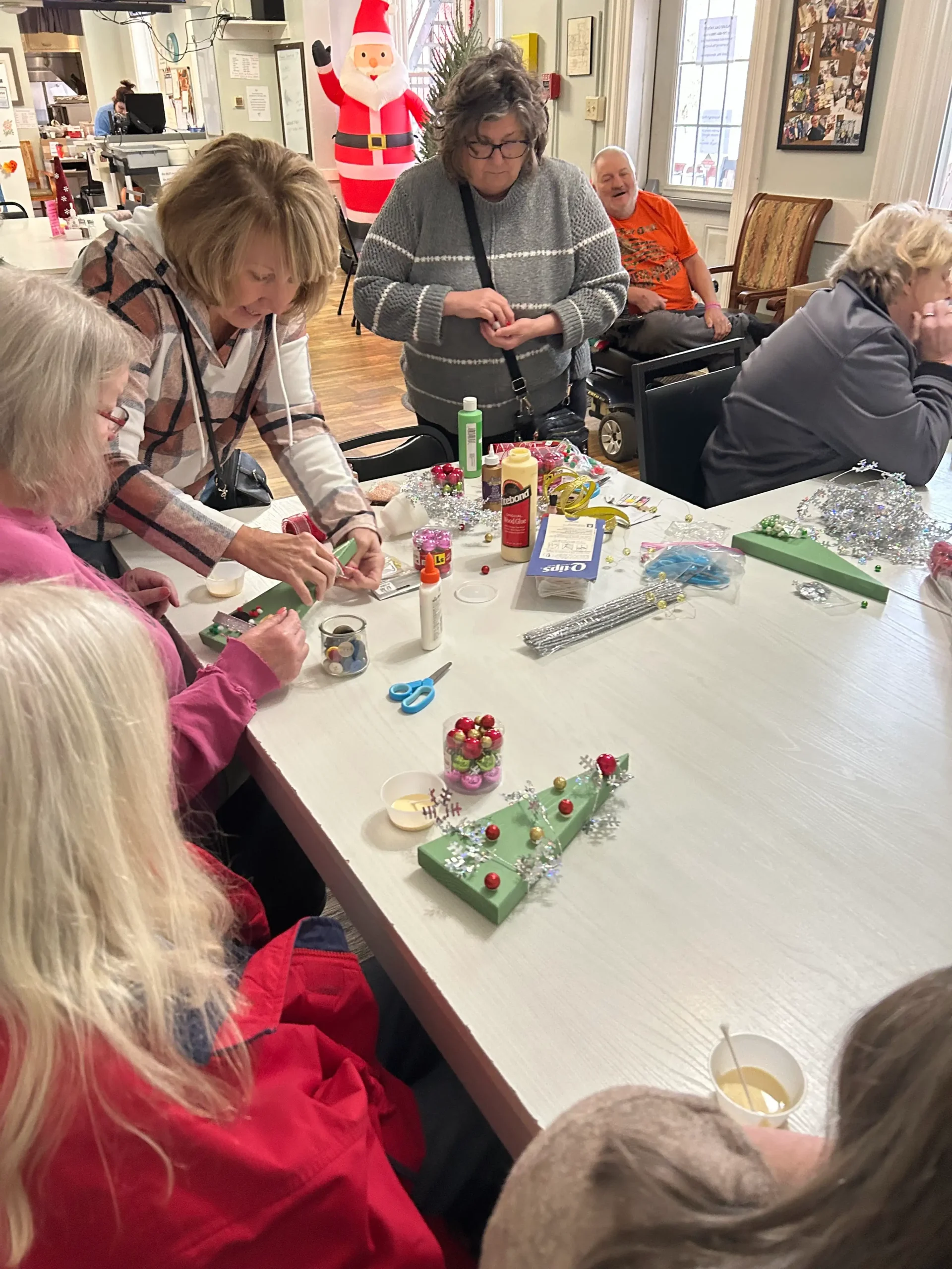 Residents engaged in a craft activity at a table.