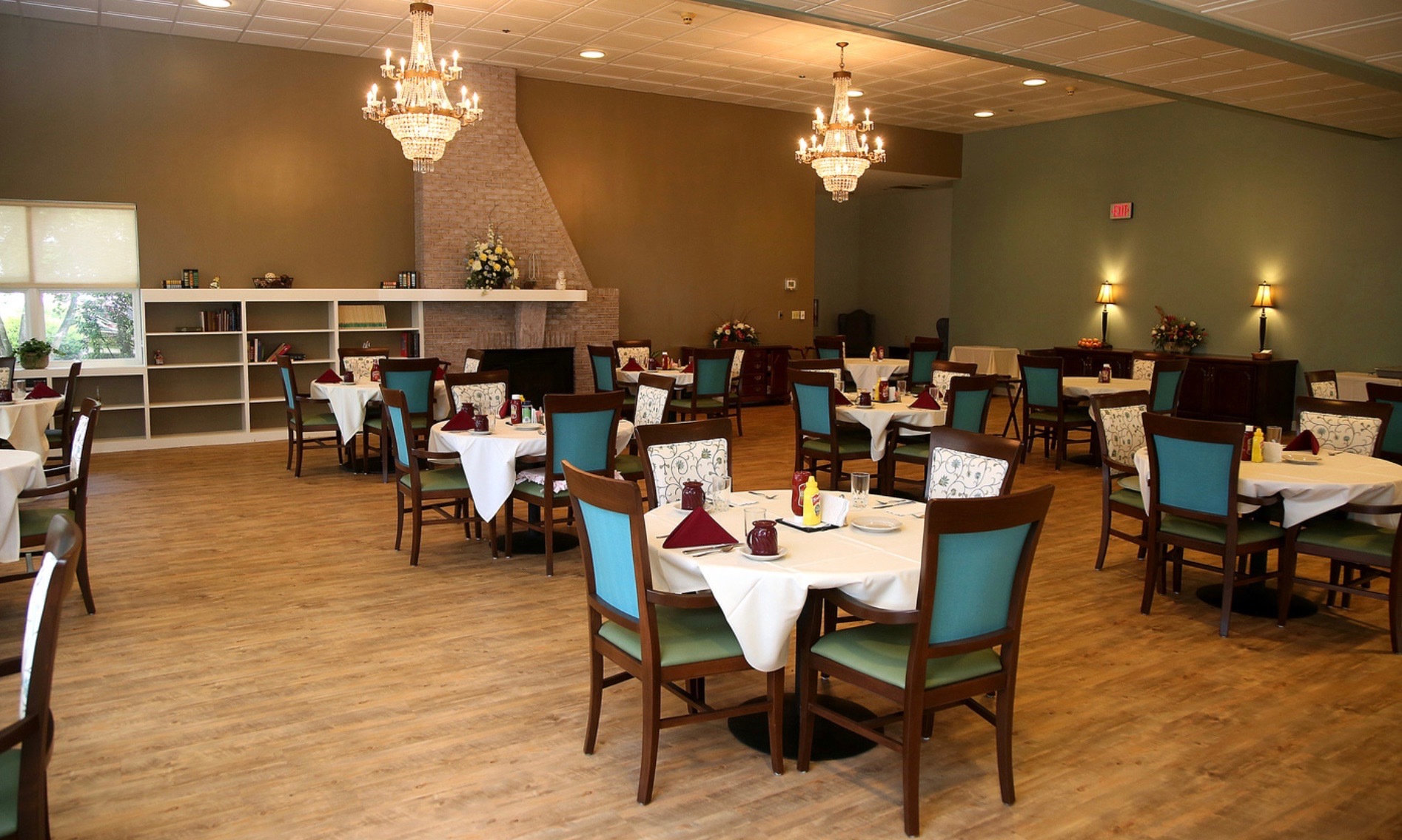 Dining area with elegant chandeliers and tables set for meals.