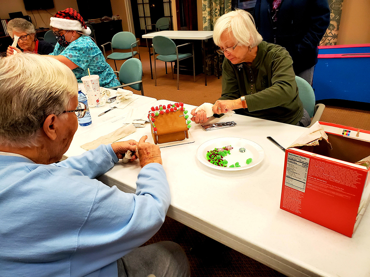 Residents decorating gingerbread houses together