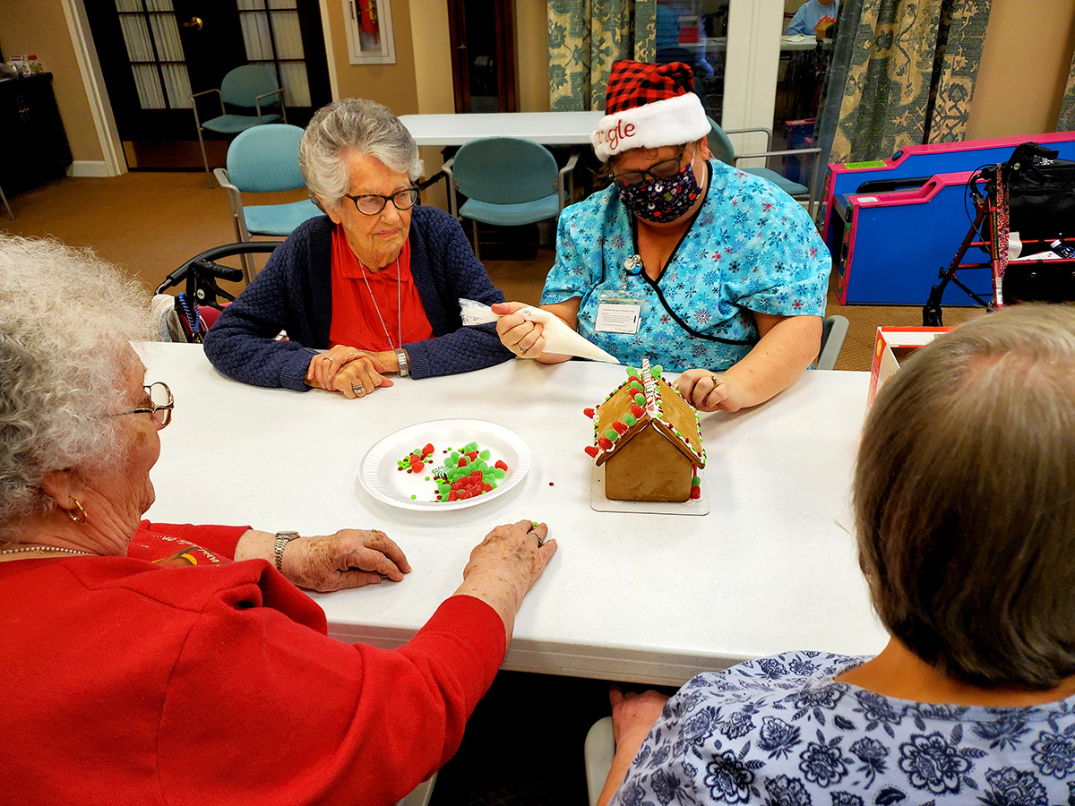 Residents engaging in a gingerbread house decorating activity.