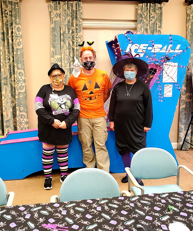 Three staff members in Halloween costumes.