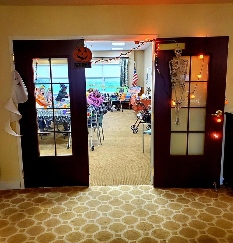 Entrance to a decorated community room with residents