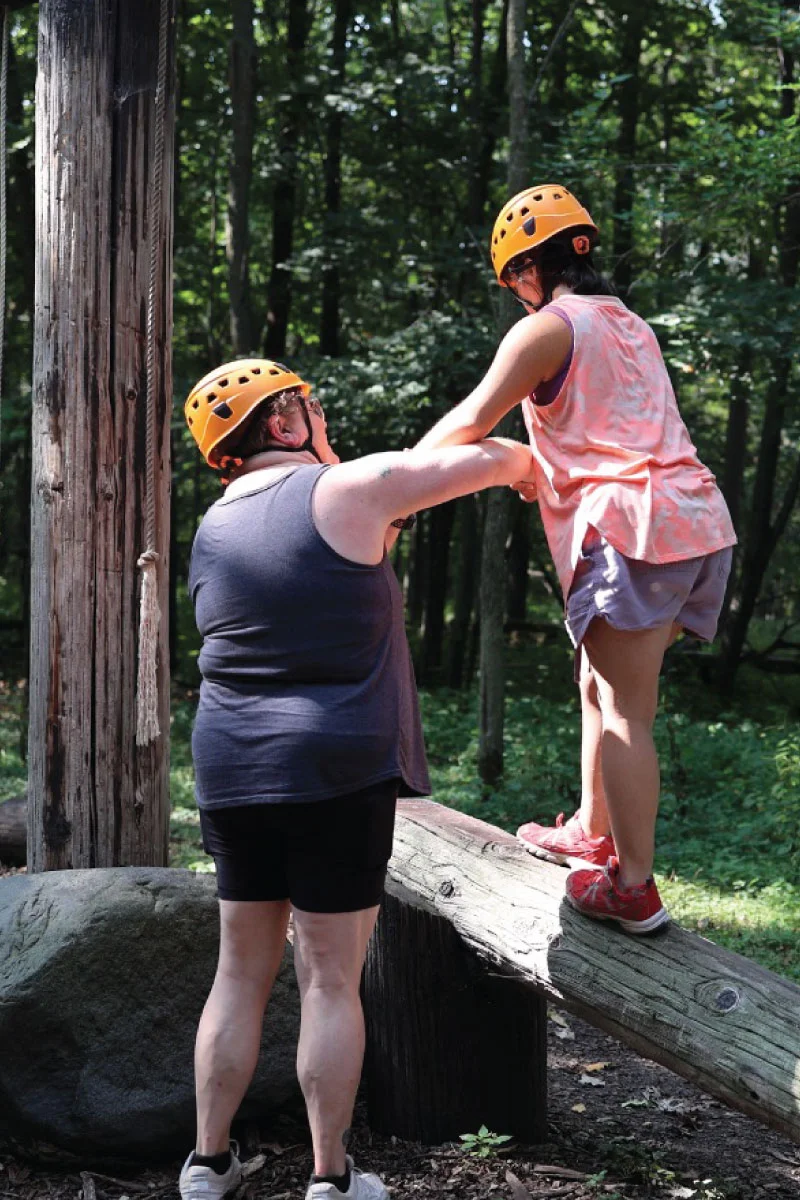 Two individuals engaging in an outdoor climbing activity.