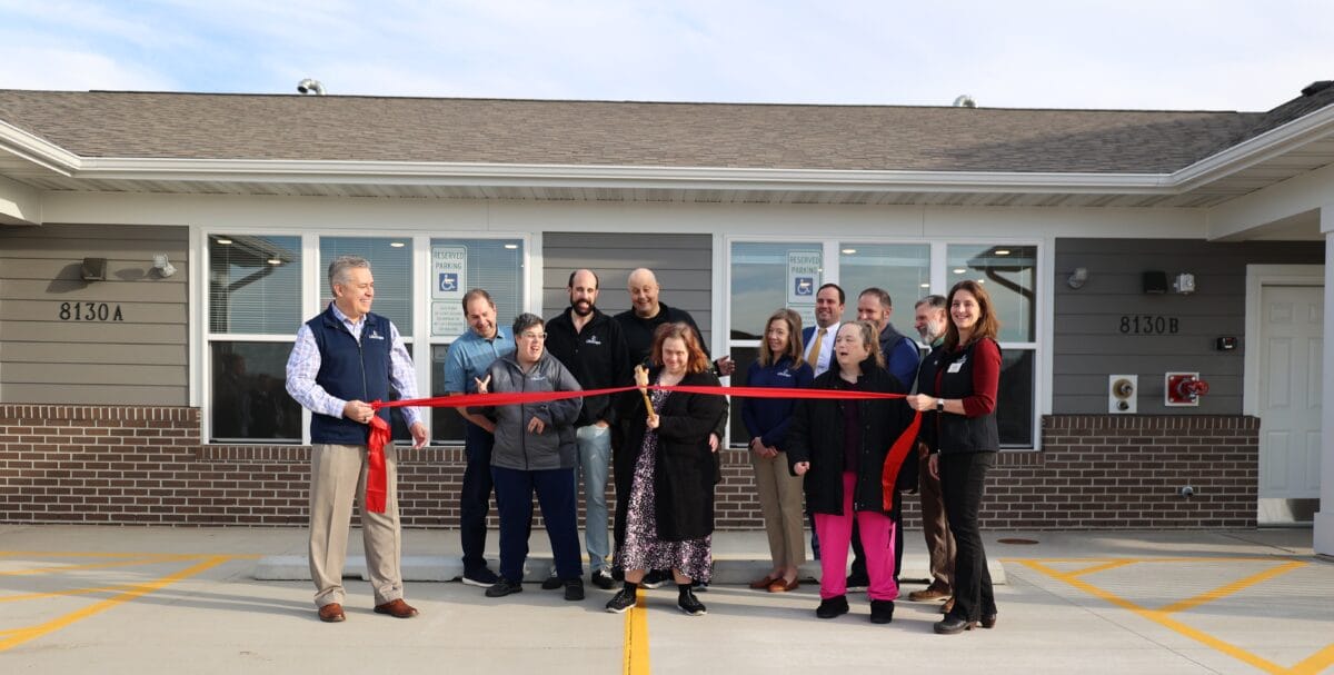 Group ribbon-cutting ceremony with residents and staff