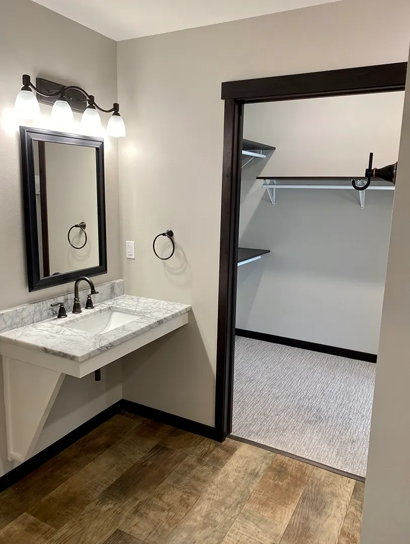 Private bathroom with vanity and closet
