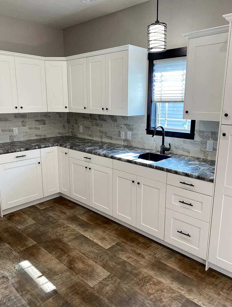 Modern kitchen with white cabinets and stone countertop