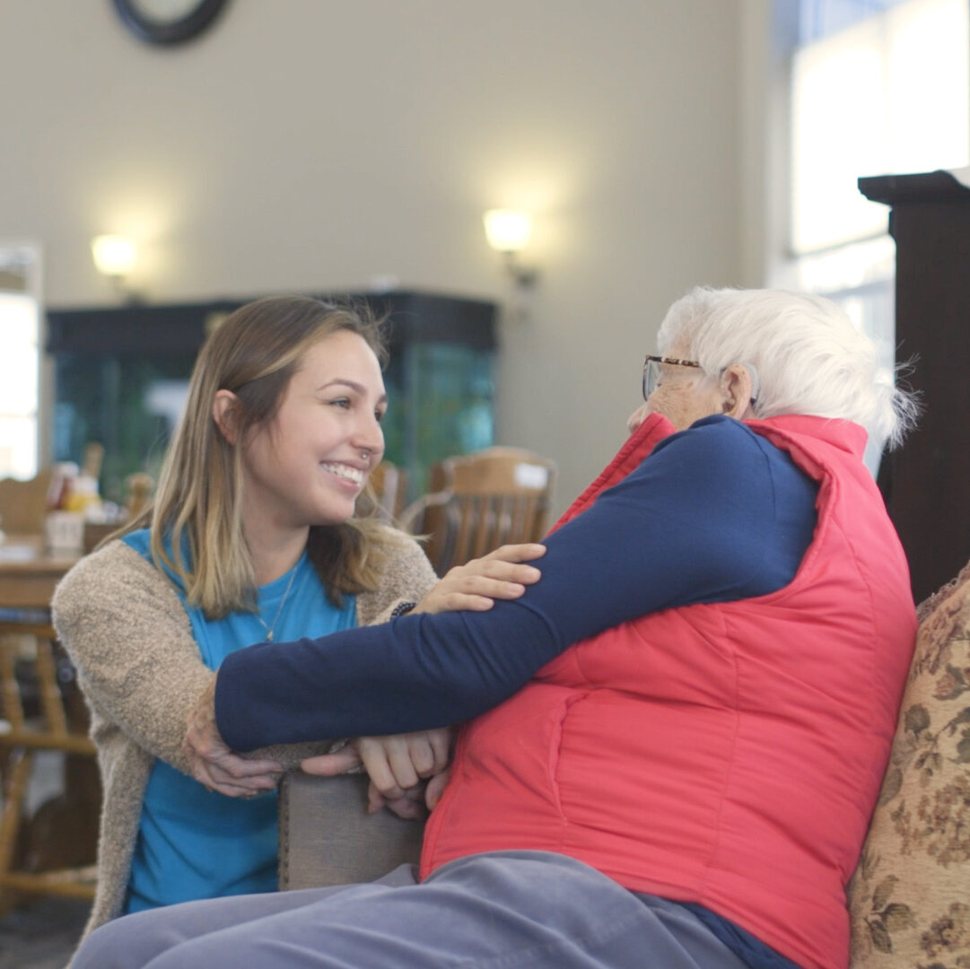 Staff interacting warmly with a resident in a common area.