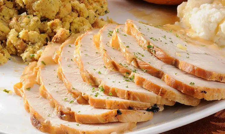 Sliced turkey with stuffing on a plate.