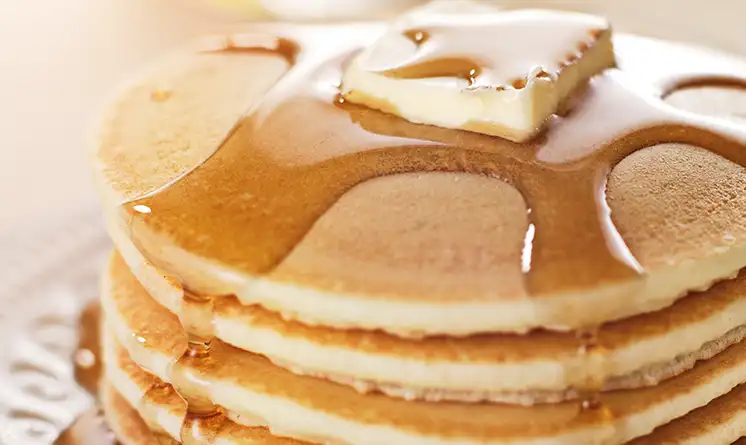 Stack of pancakes with butter and syrup