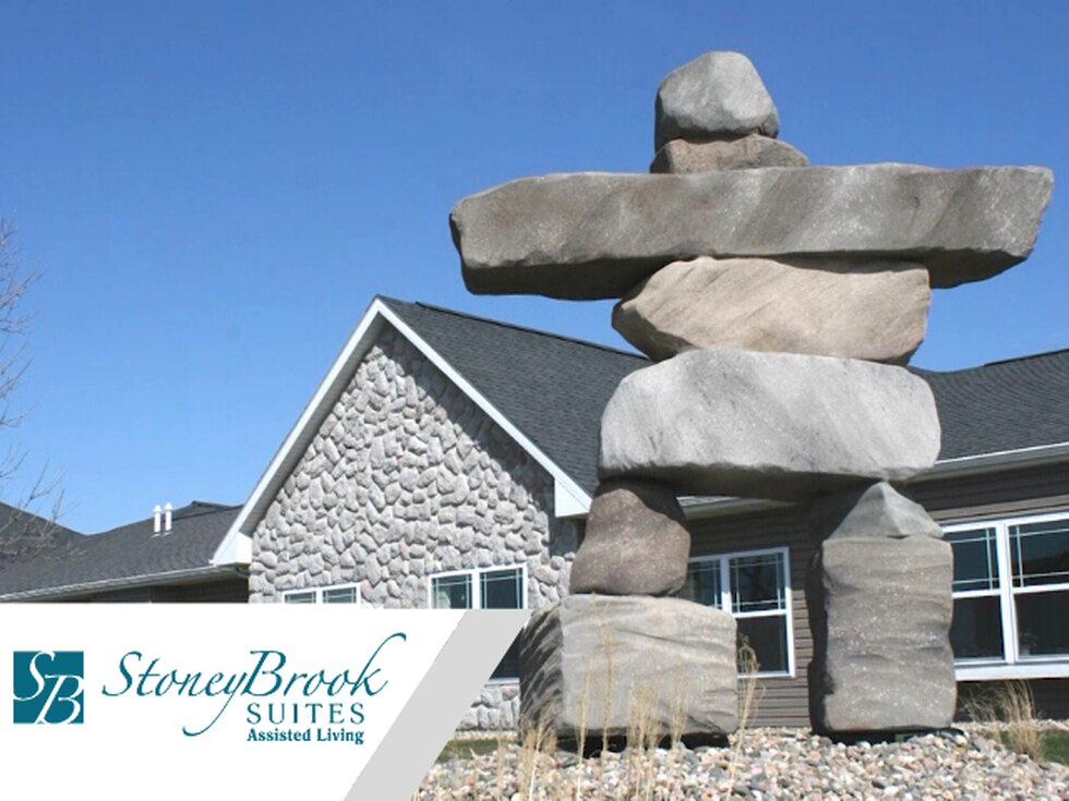 Exterior view of StoneyBrook Suites with logo