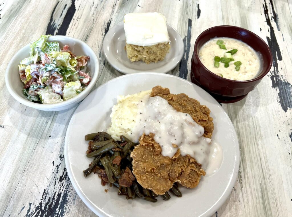 Hearty meal with fried chicken, salad, and dessert.