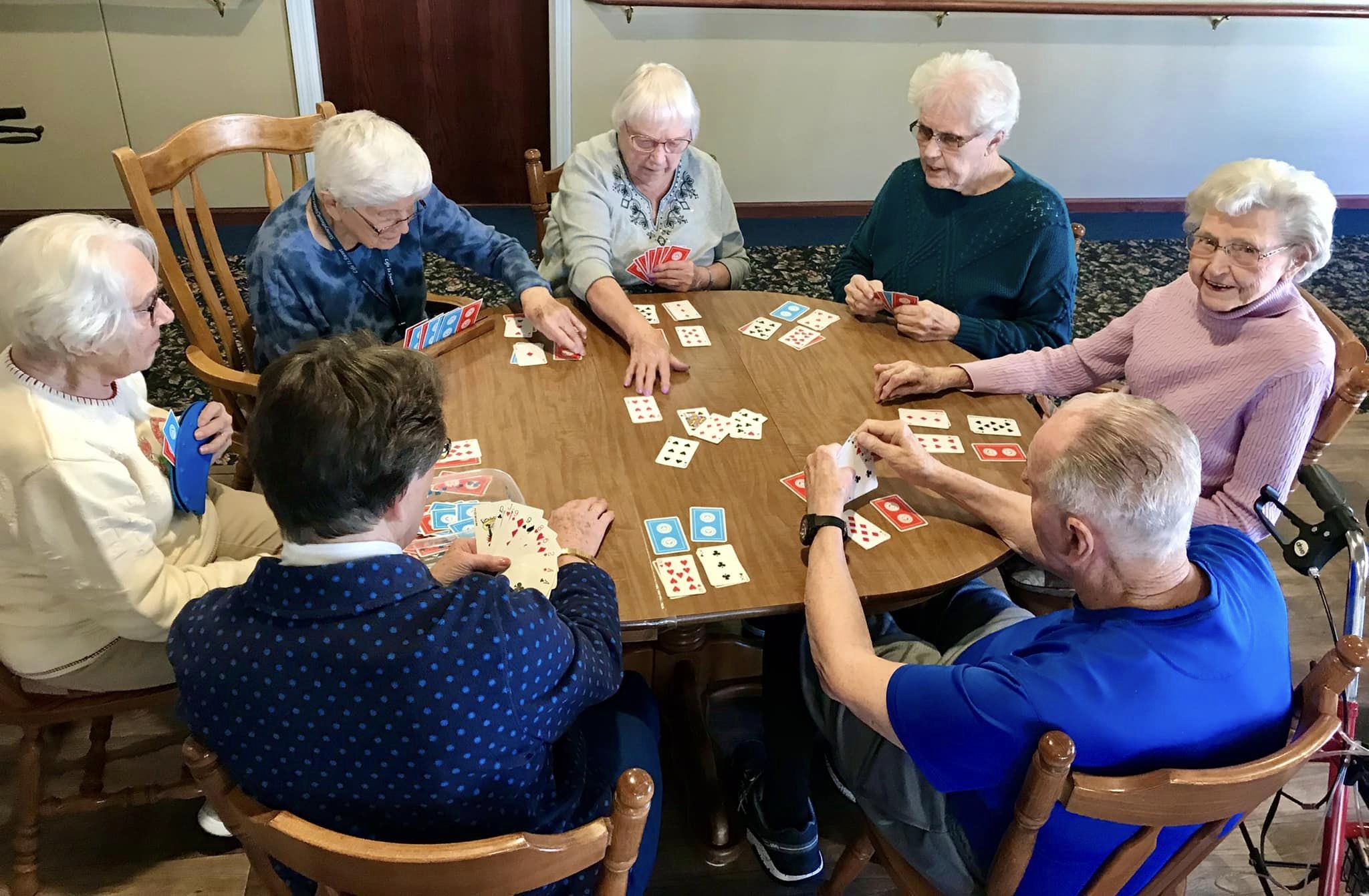 Seniors playing cards around a table