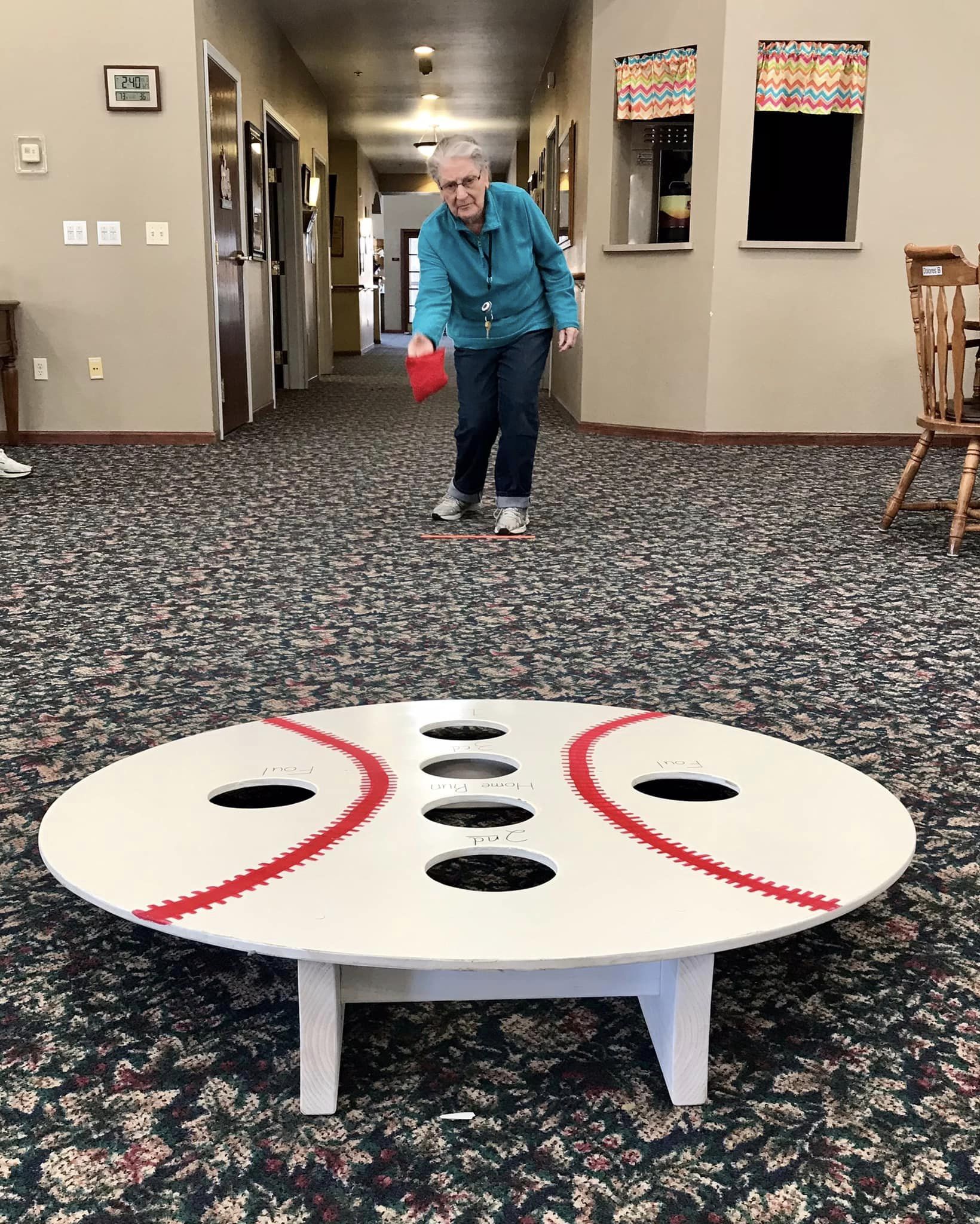 Resident playing a game in the facility hallway.