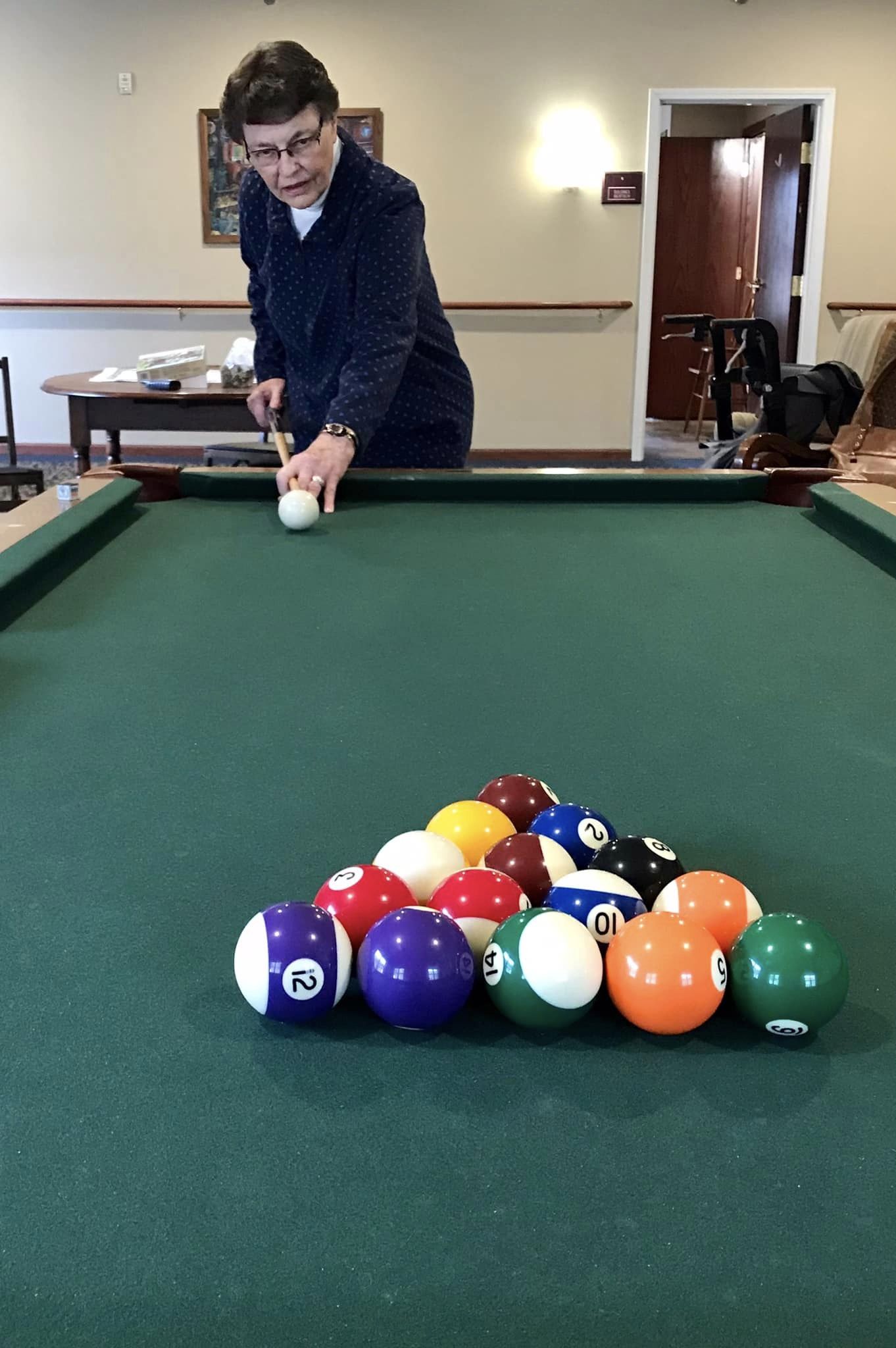 Resident playing billiards in the activity room