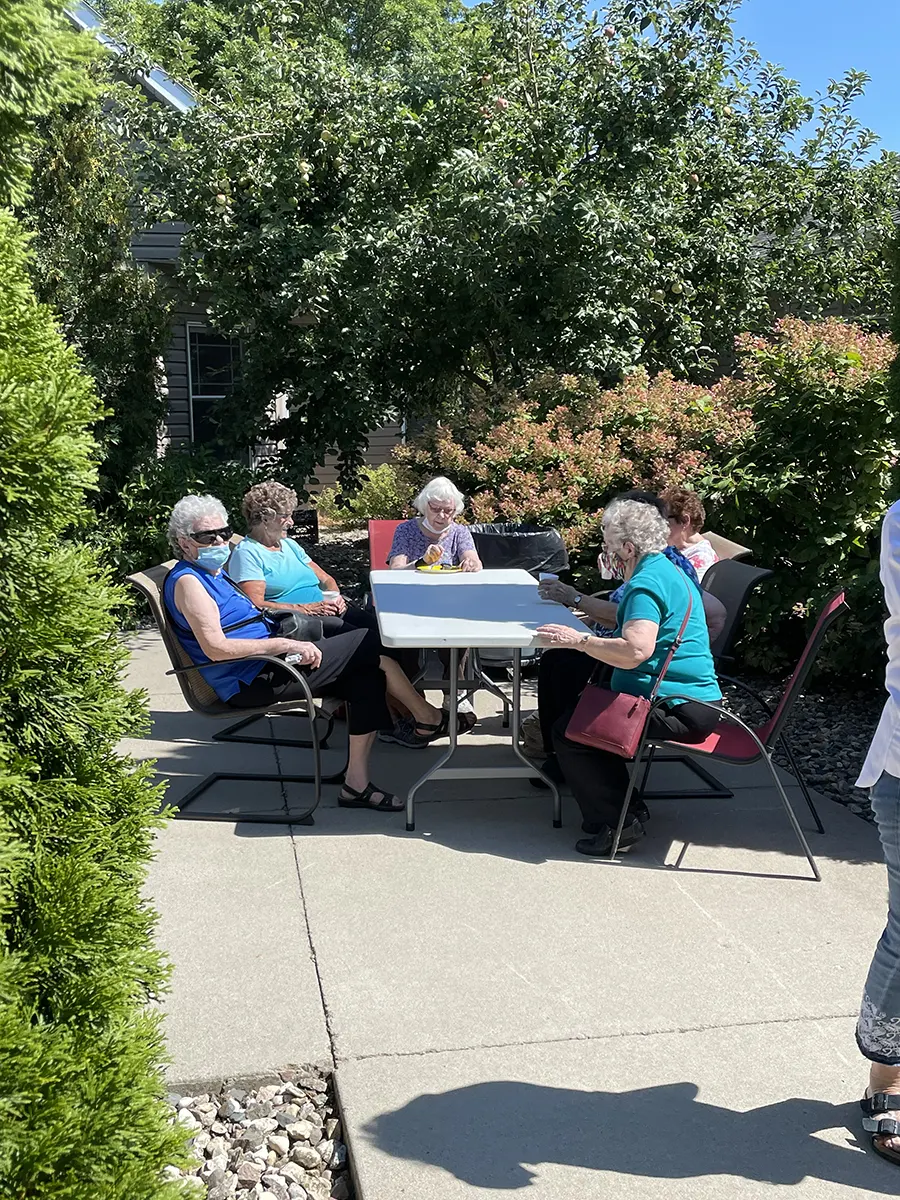 Residents enjoying an outdoor activity at a table.