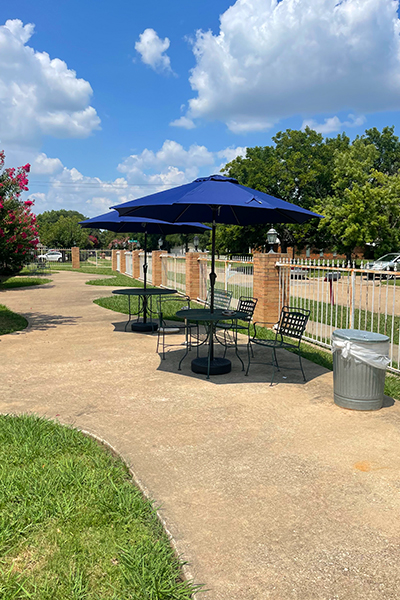 Outdoor seating area with umbrellas and a pathway.