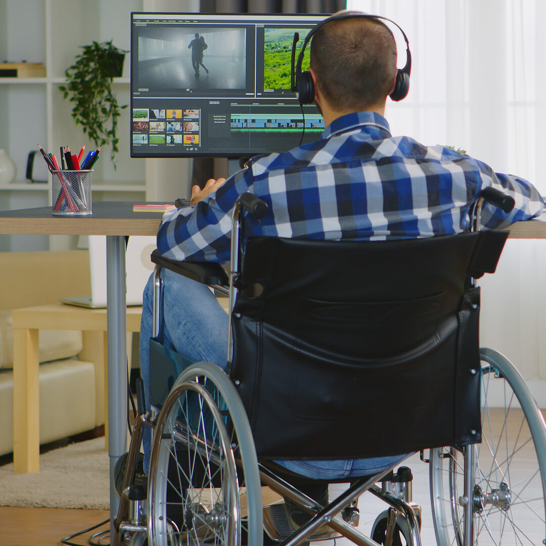 Individual using a computer in a wheelchair.
