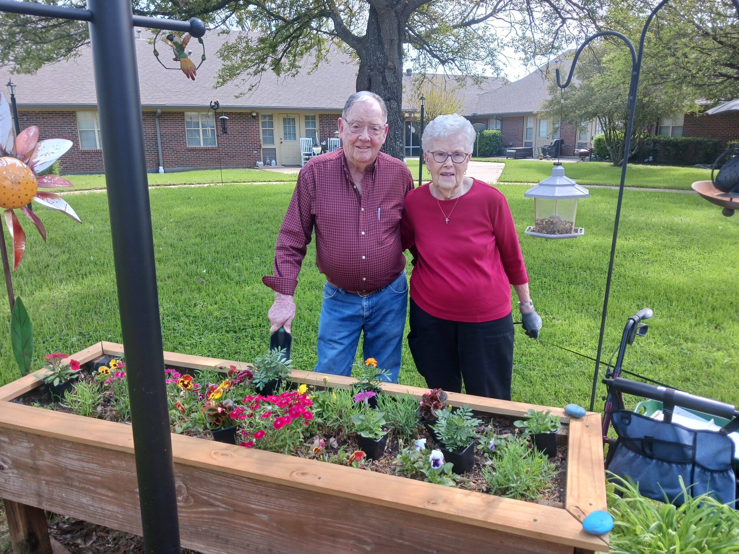 Two residents smiling in a garden.
