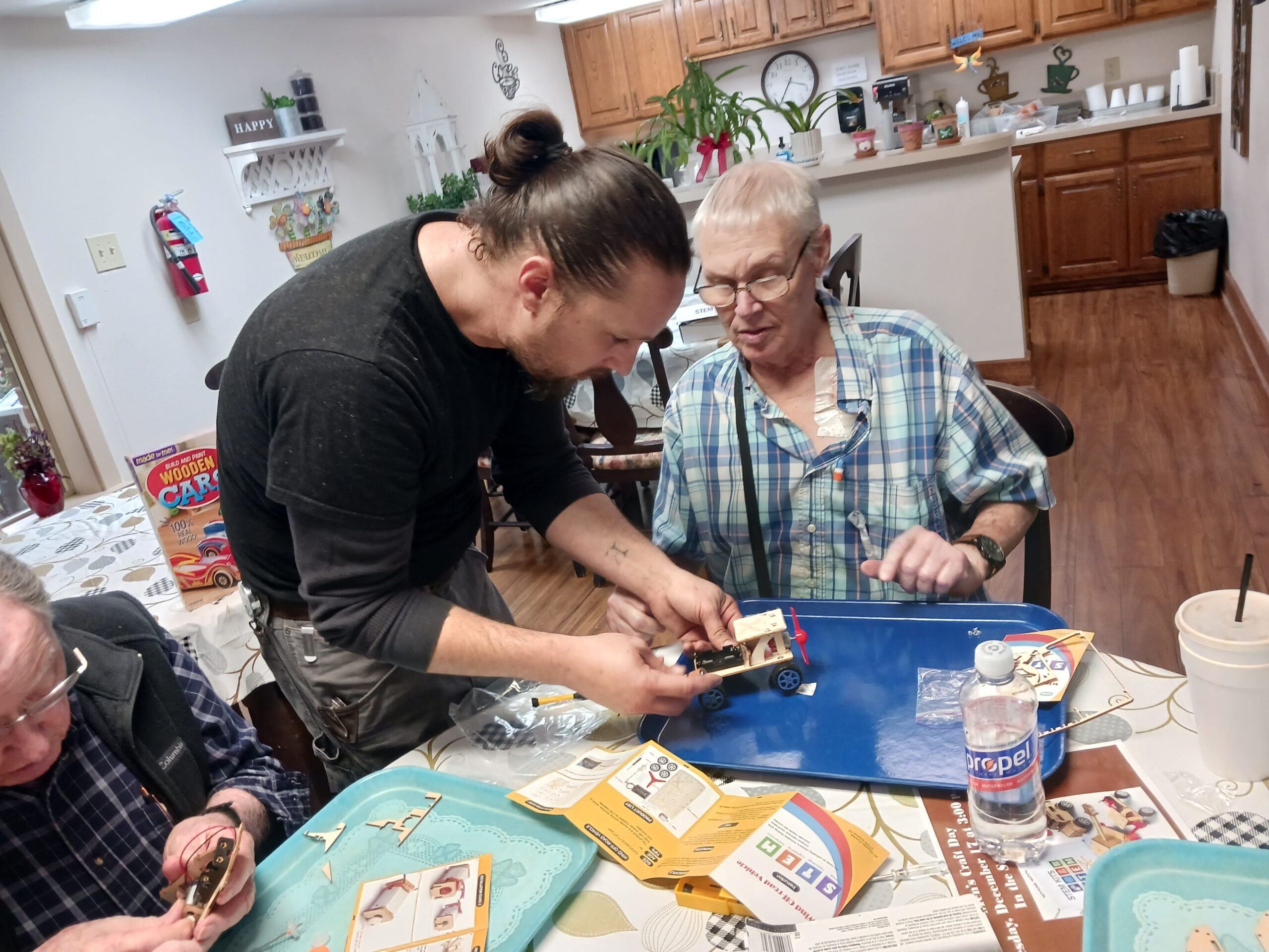 Residents engaged in a crafting activity indoors.