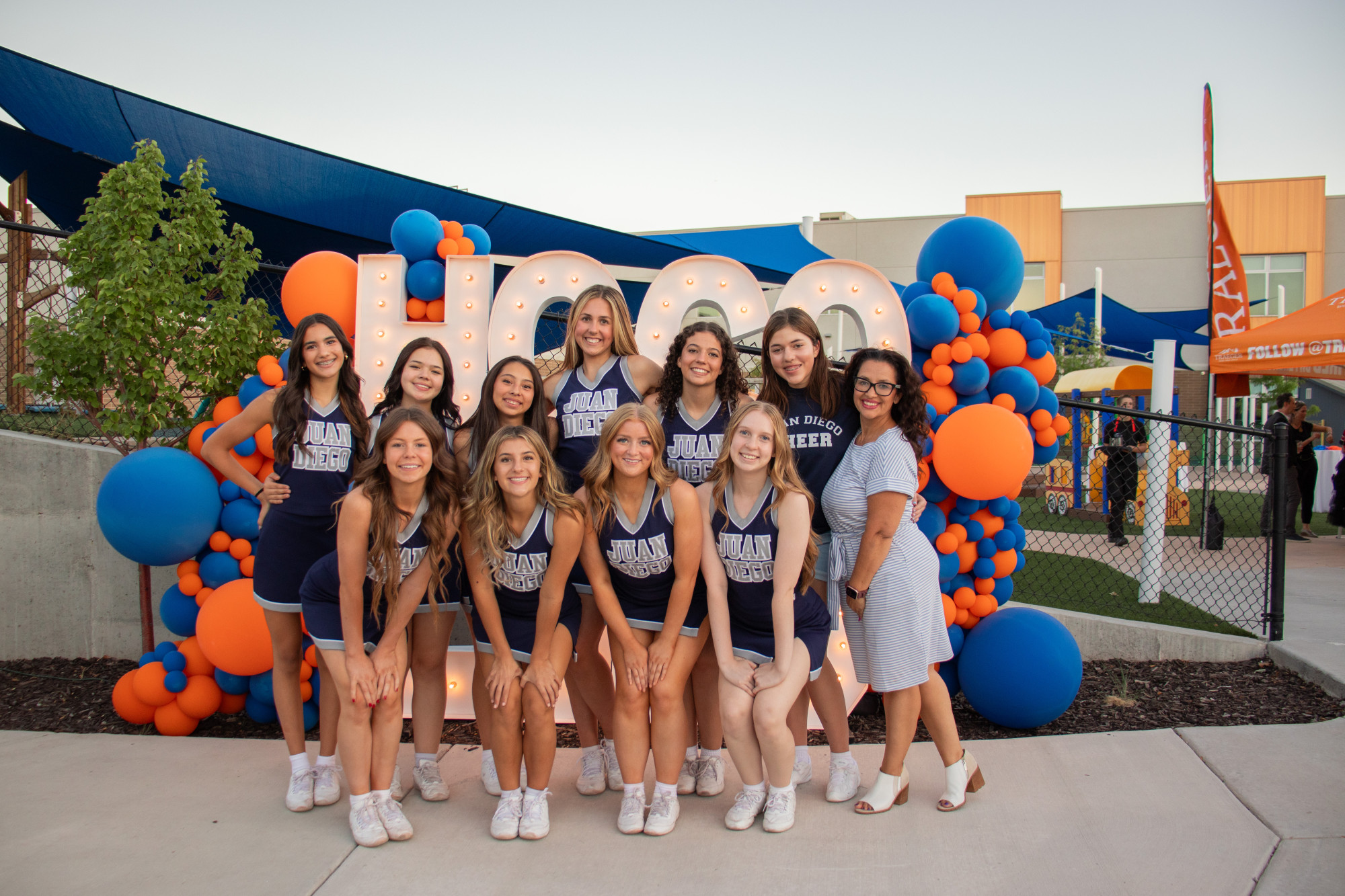 Cheerleading team poses at an event with decorations.