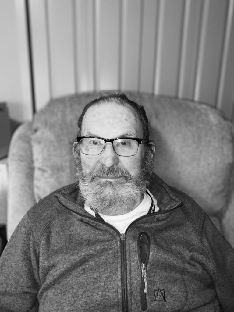 Senior man with glasses sitting in a chair