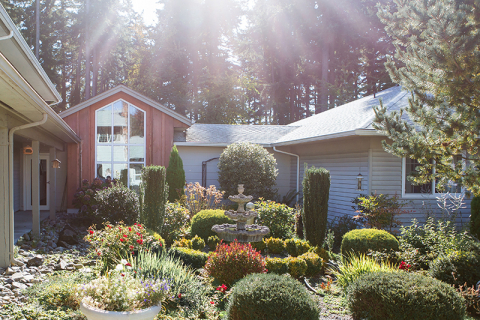 Beautifully landscaped garden area with flowers and fountain.