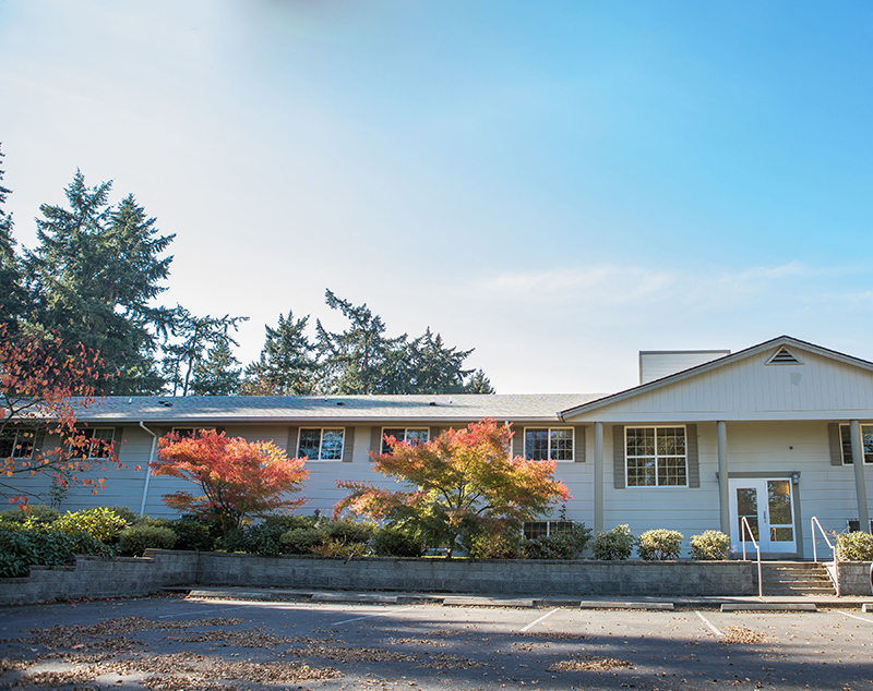 Exterior view of a senior living facility surrounded by trees