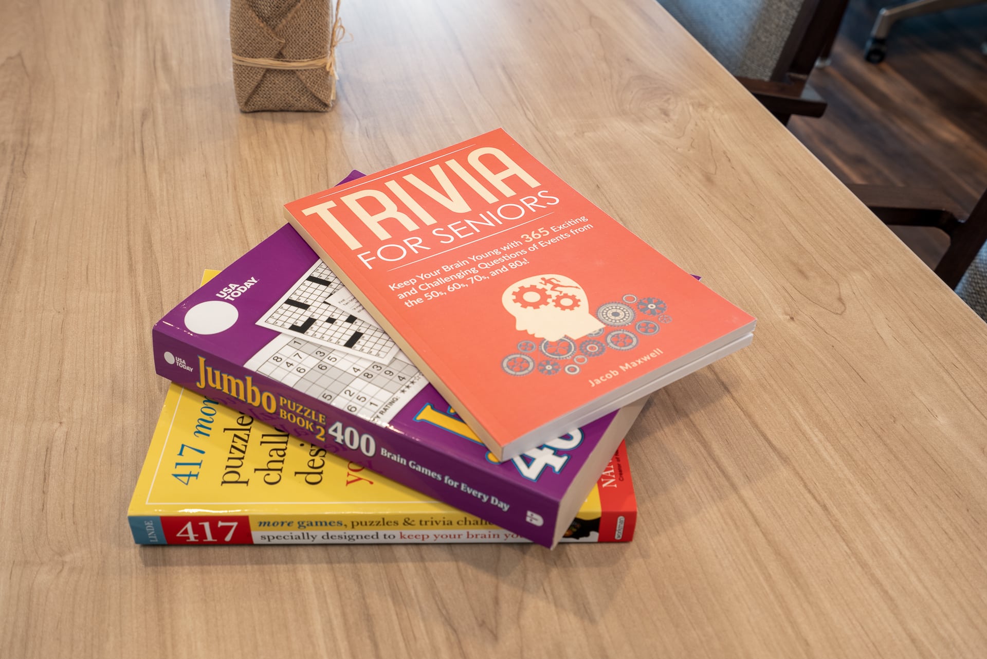 Stack of trivia and puzzle books on a table.