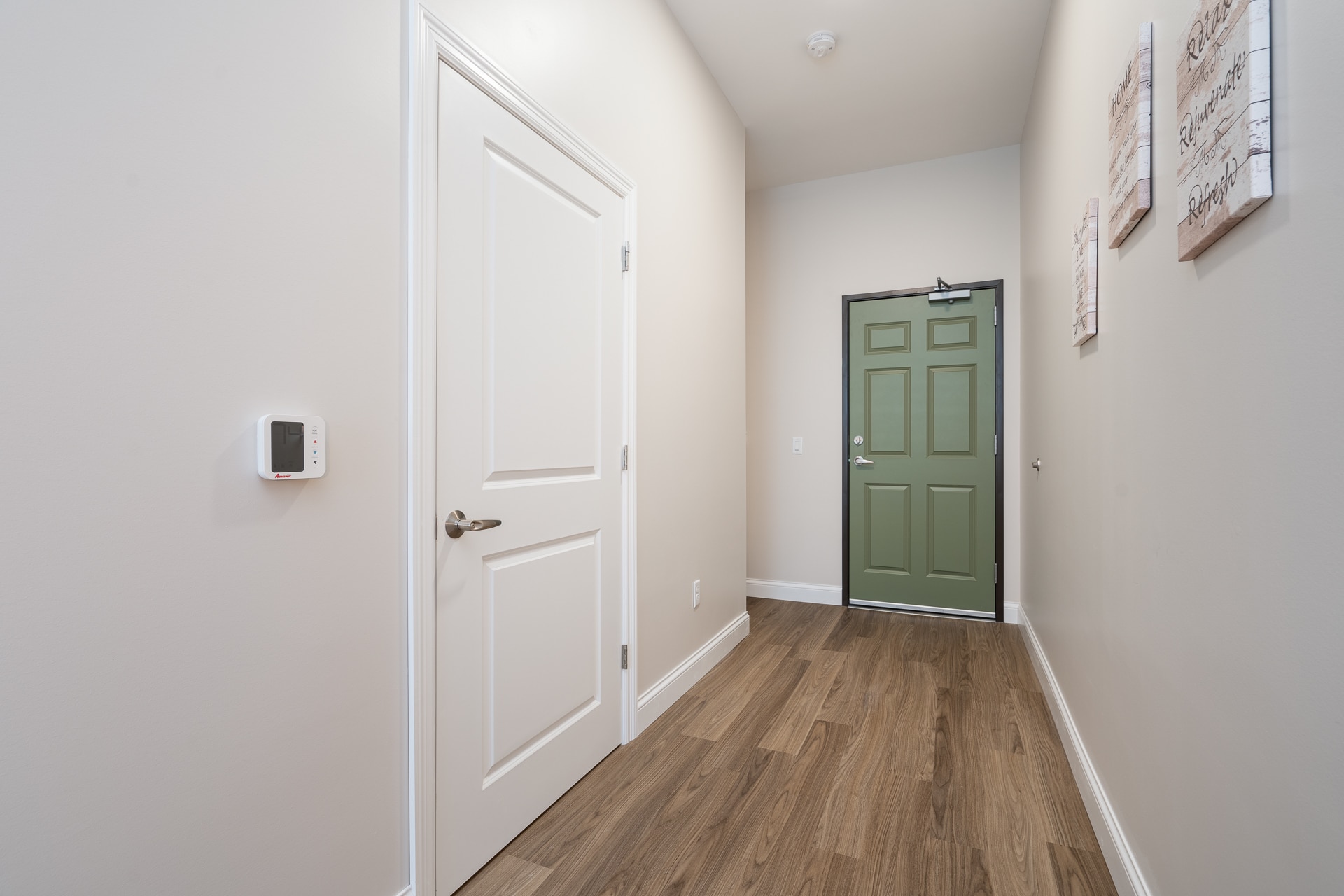 Interior hallway with a green door and wall decor.