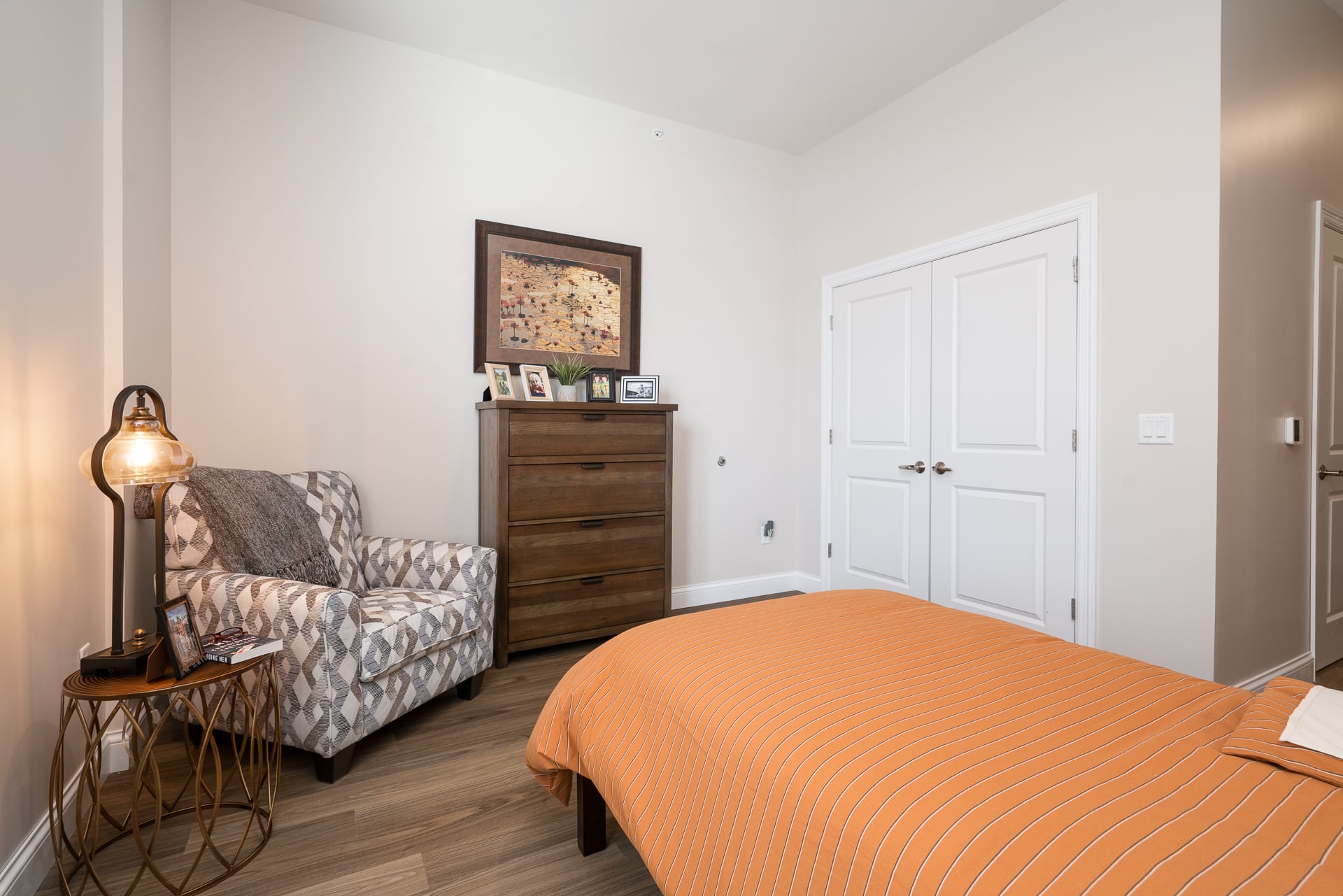 Cozy resident room with a bed and chair.