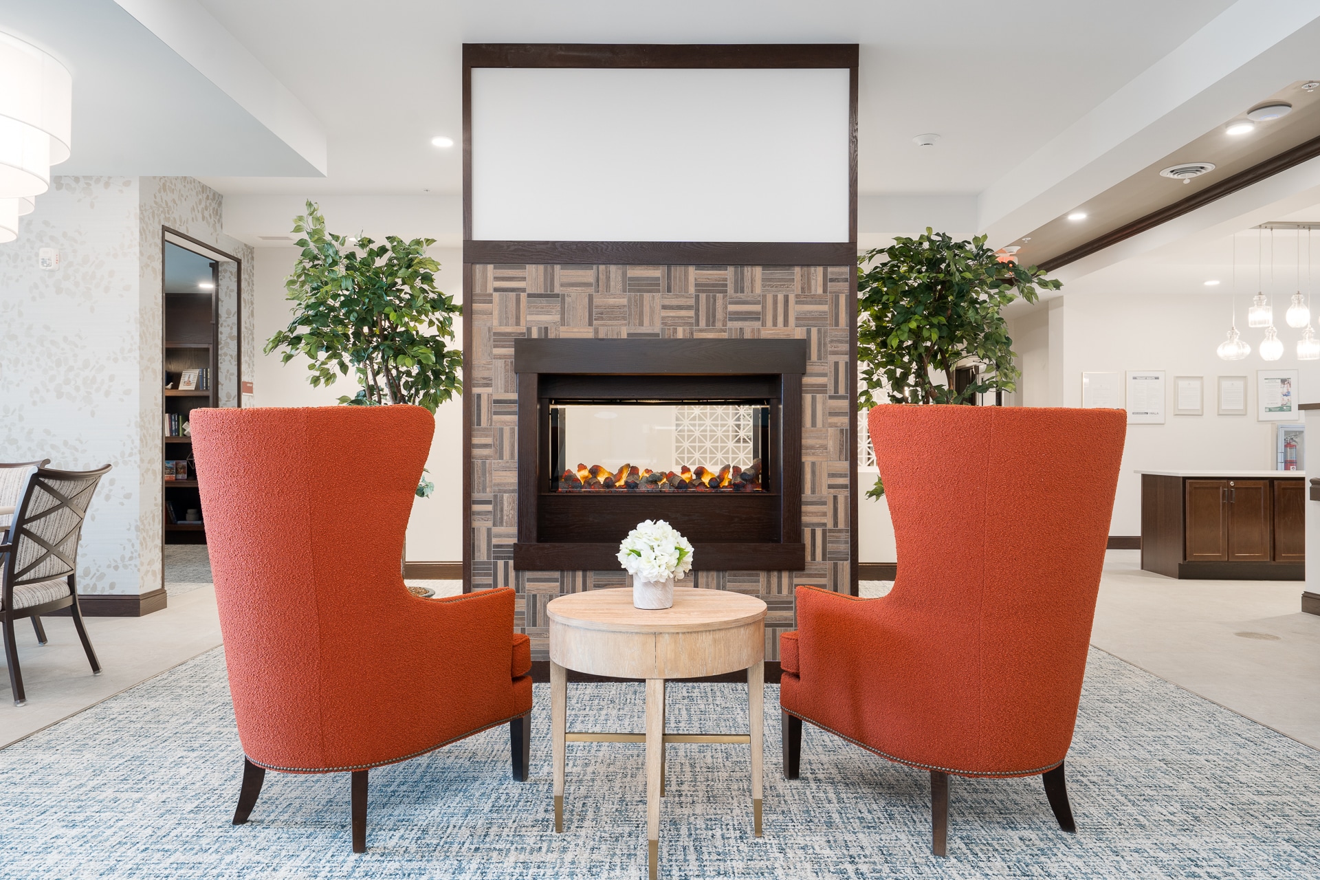 Cozy common area with two armchairs and a fireplace.