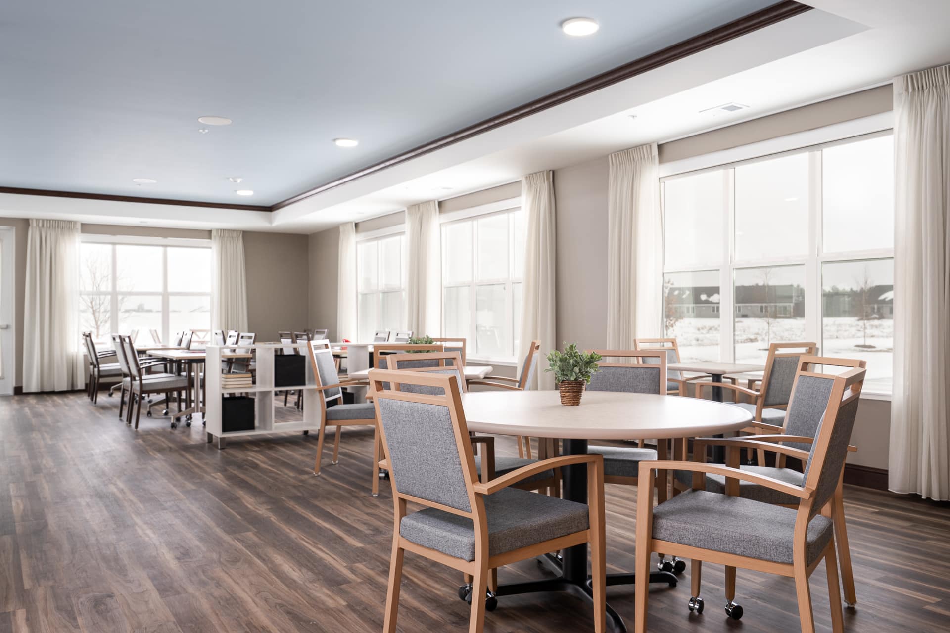 Bright common area with dining tables and chairs.