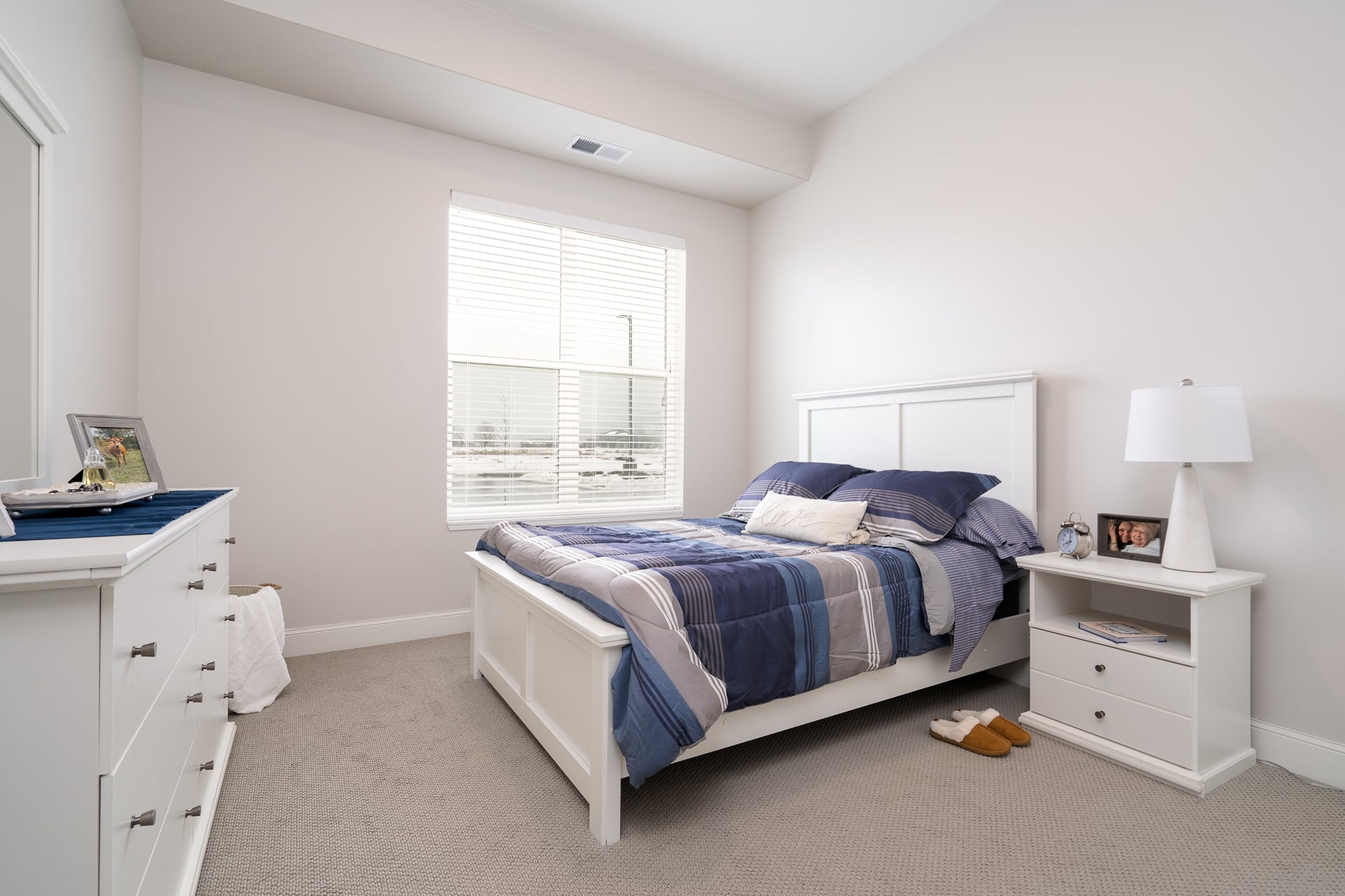 Cozy private bedroom with a bed and dresser.