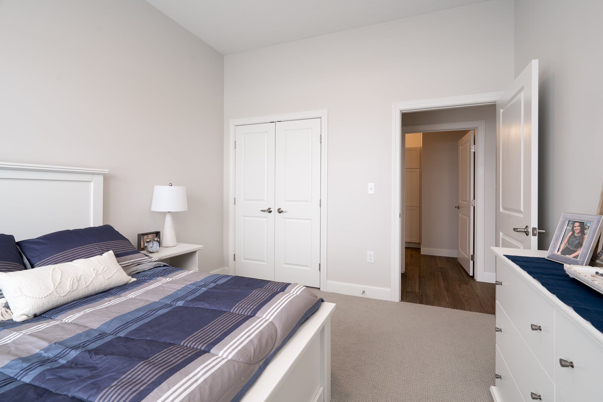 Well-furnished private bedroom with a bed and dresser