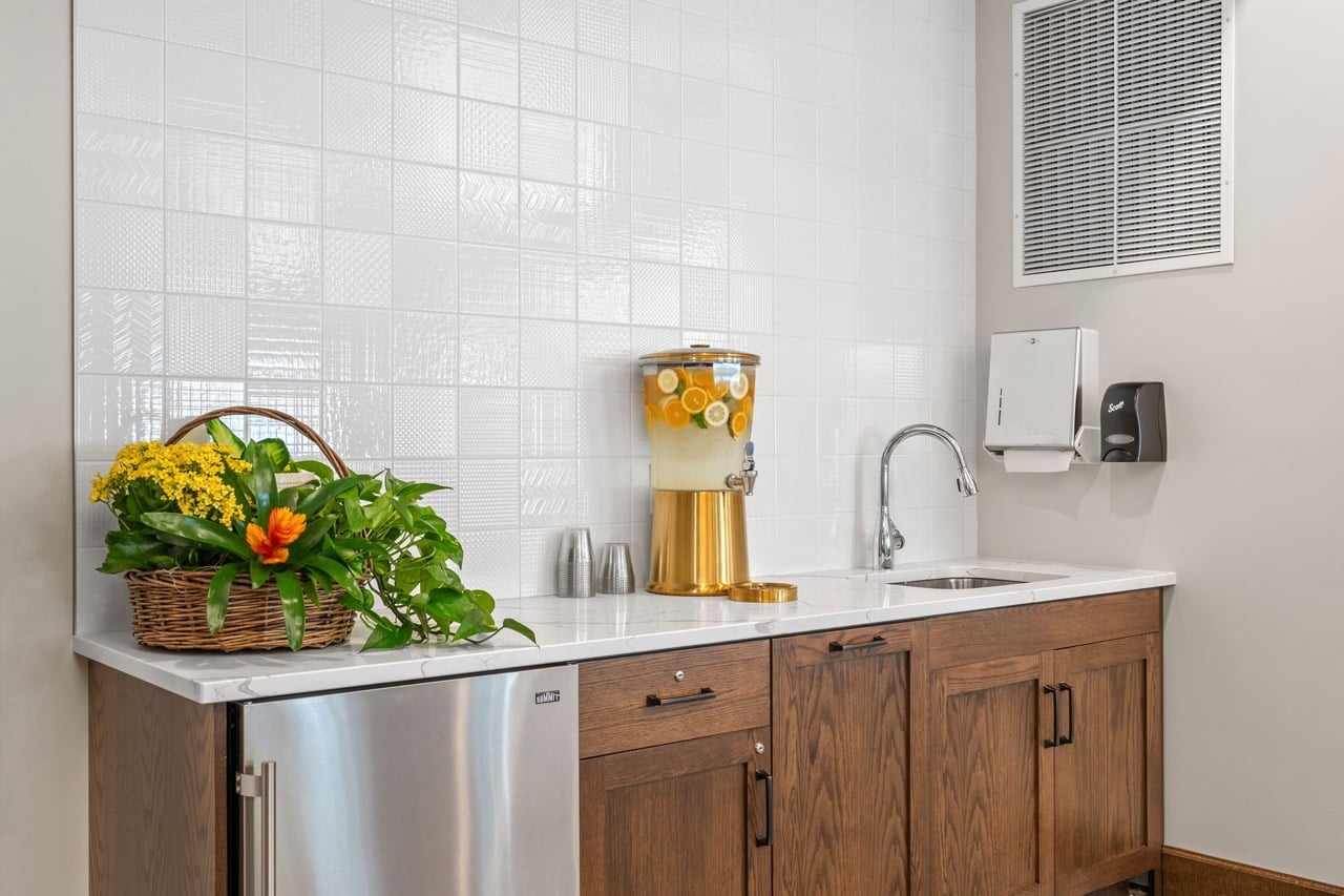 Kitchenette area with beverages and plants.
