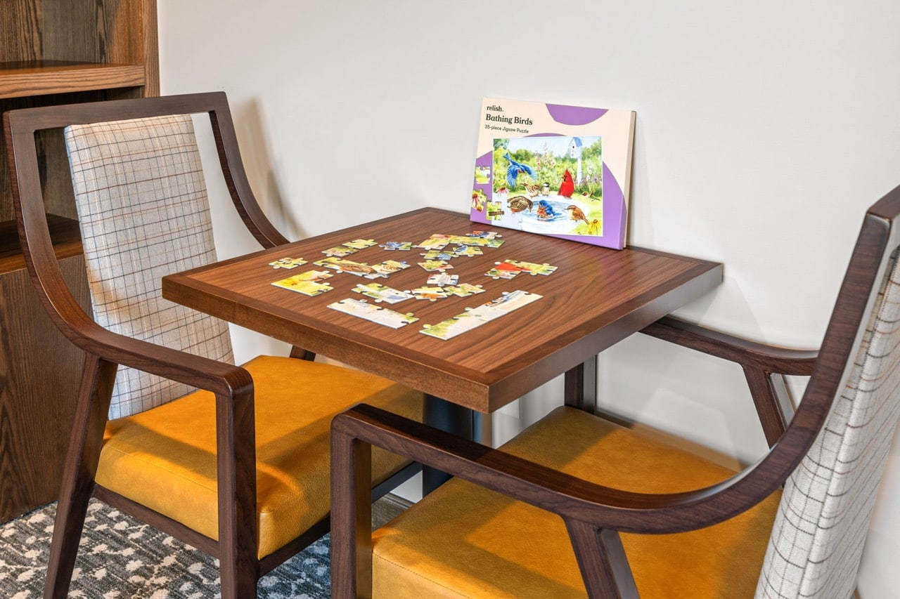 Table with a puzzle and a book in a cozy setting.