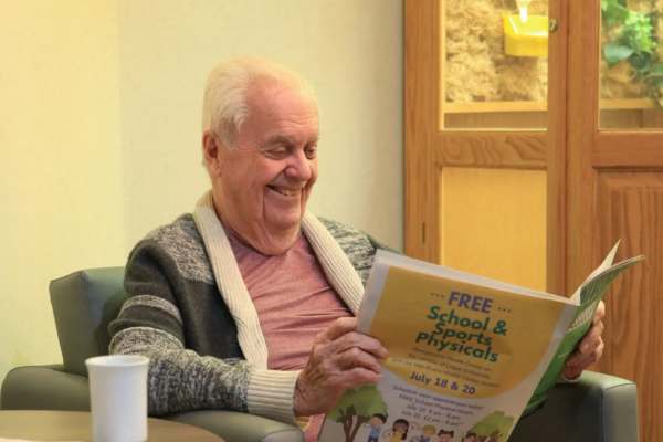 Elderly man reading a newspaper in a lounge