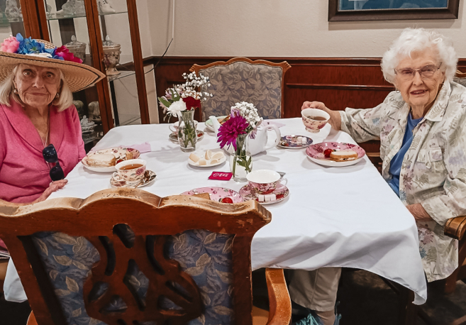 Two residents enjoying tea in a dining area.