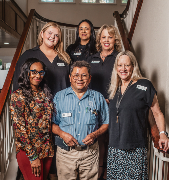 Staff members posing on a staircase inside the facility.