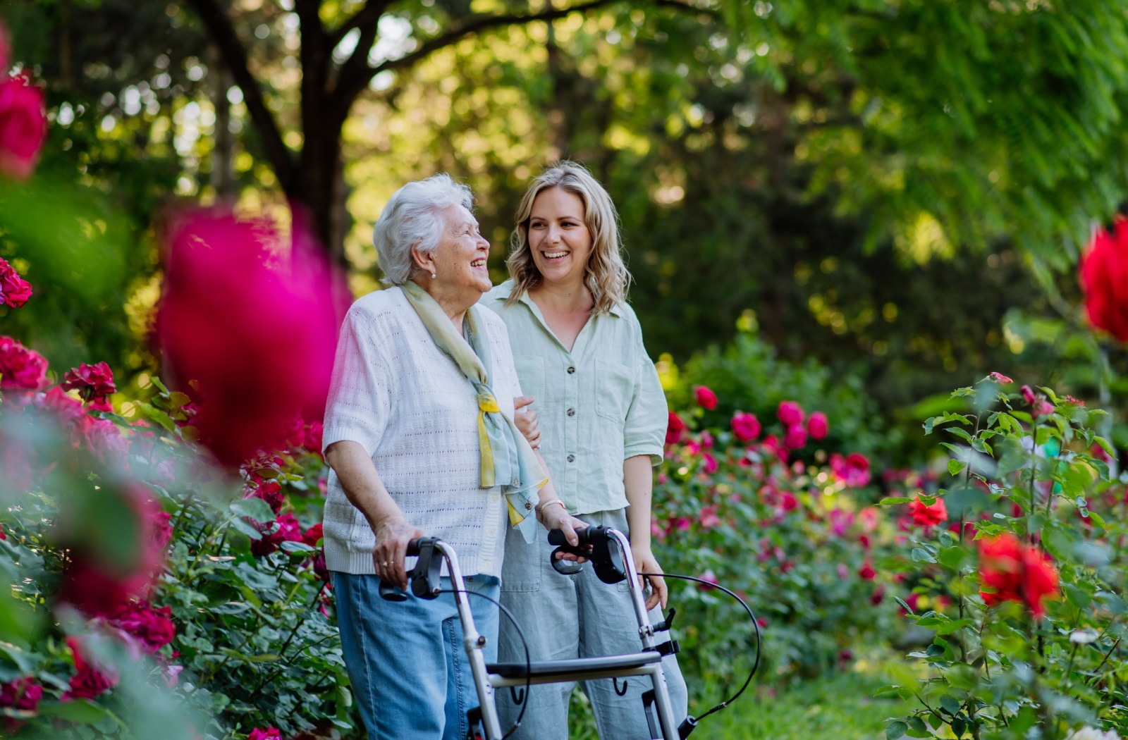 Senior woman enjoying the garden with a caregiver.