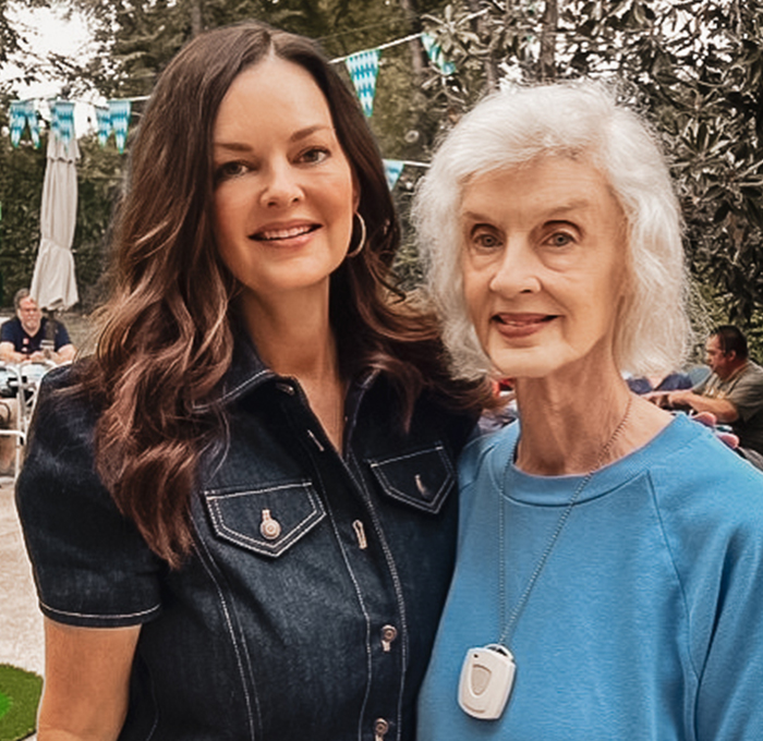 A caregiver and resident smiling outdoors