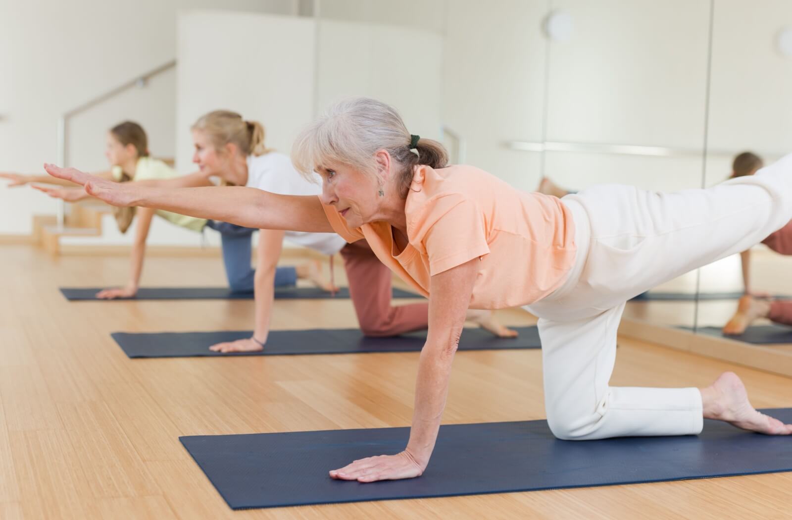 Seniors engaged in a yoga class indoors.