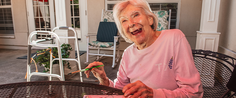 Resident engaged in an art activity outdoors.