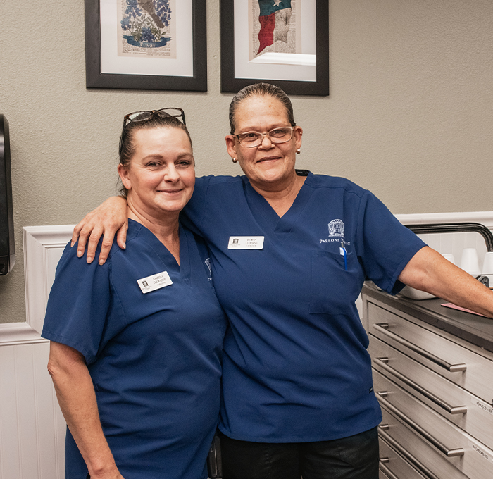 Two staff members posing in a facility setting.
